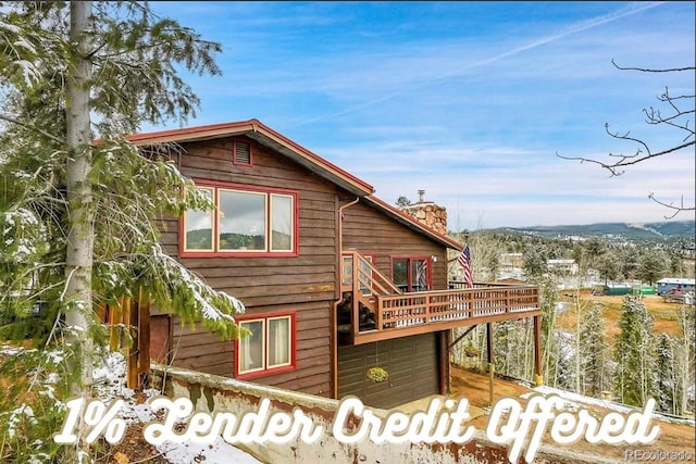 637 Rock Rd, Bailey, CO 80421 - back of property with a chimney, a garage, and a wooden deck