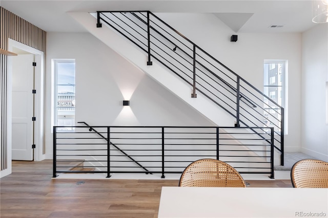 stairs with visible vents, wood finished floors, and baseboards