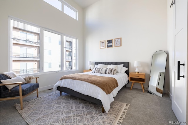 carpeted bedroom featuring baseboards and a towering ceiling