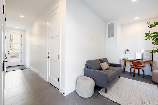 living area with tile patterned floors, recessed lighting, visible vents, and baseboards