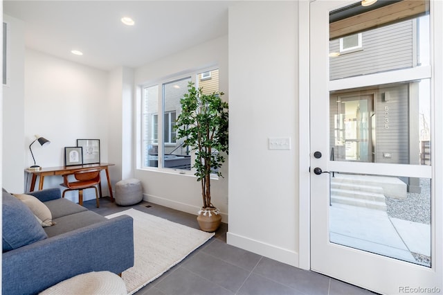 interior space featuring recessed lighting, baseboards, and dark tile patterned flooring