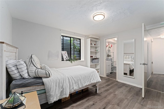 6621 E Peakview Pl, Centennial, CO 80111 - bedroom featuring wood finished floors, a textured ceiling, baseboards, and ensuite bathroom