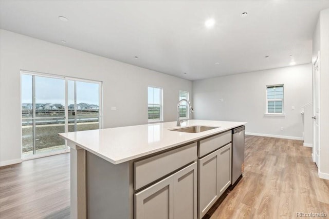 19019 E 94th Pl, Commerce City, CO 80022 - kitchen with a sink, dishwasher, gray cabinetry, light wood-type flooring, and light countertops