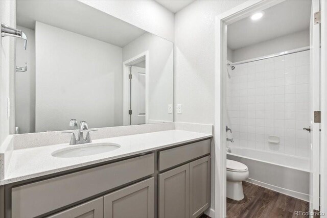 19019 E 94th Pl, Commerce City, CO 80022 - bathroom with toilet, vanity, wood finished floors, and tub / shower combination