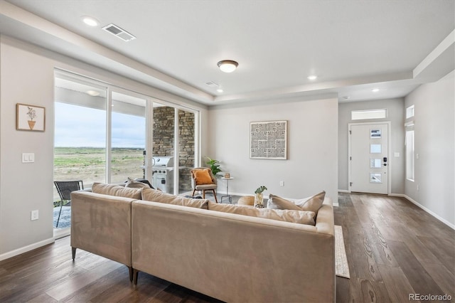 5142 N Quemoy Ct, Aurora, CO 80019 - living room with a tray ceiling, dark wood-style floors, recessed lighting, and baseboards
