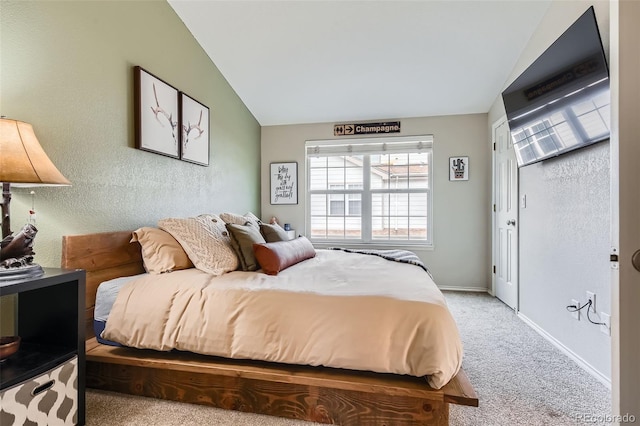 bedroom with light colored carpet, vaulted ceiling, and baseboards