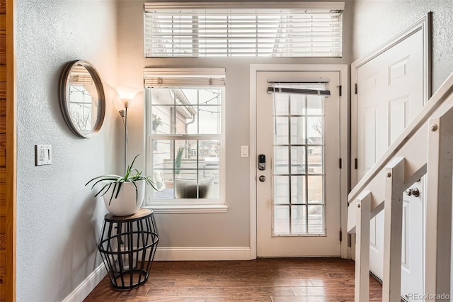 entryway featuring a textured wall, dark wood finished floors, and baseboards