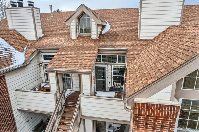 exterior space with a shingled roof and a chimney