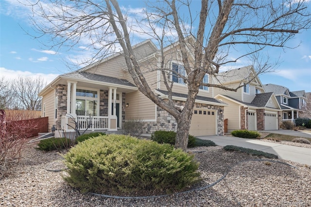 view of front of property with a porch, a garage, stone siding, and driveway