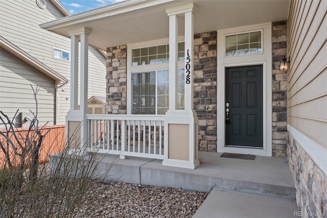 property entrance featuring stone siding and a porch