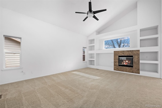 unfurnished living room featuring plenty of natural light, built in shelves, and carpet