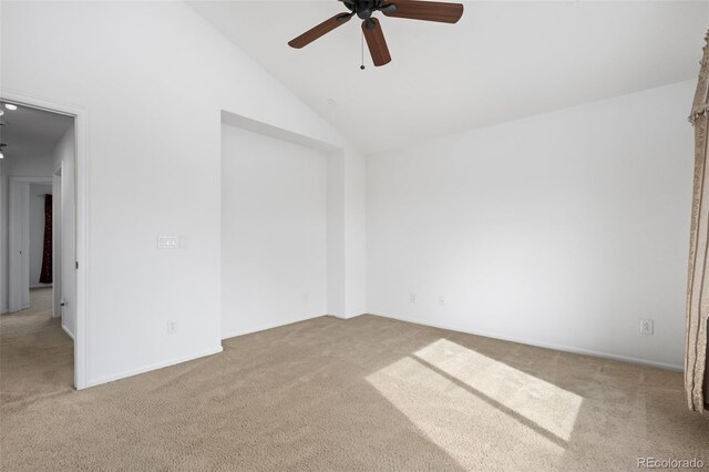 carpeted spare room with a ceiling fan and vaulted ceiling