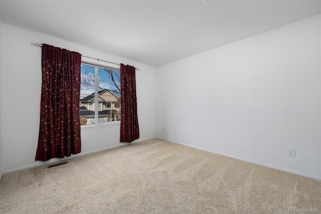 unfurnished room with carpet flooring, baseboards, and visible vents