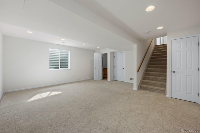 below grade area with recessed lighting, light colored carpet, and stairs