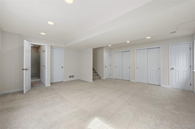 finished below grade area with recessed lighting, stairway, light colored carpet, and visible vents