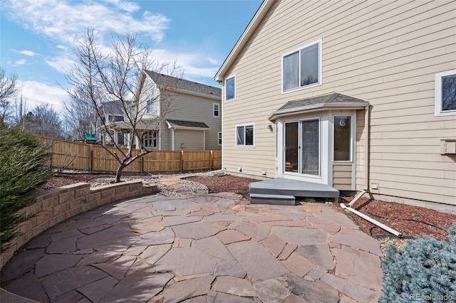 rear view of house with fence and a patio area