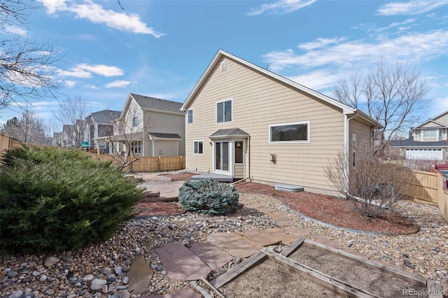 rear view of property featuring a patio and fence