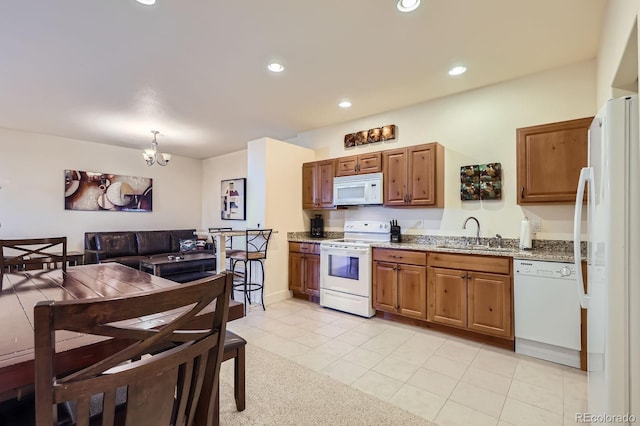 11876 Coal Creek Heights Dr, Golden, CO 80403 - kitchen with white appliances, light stone countertops, a chandelier, light tile patterned floors, and recessed lighting