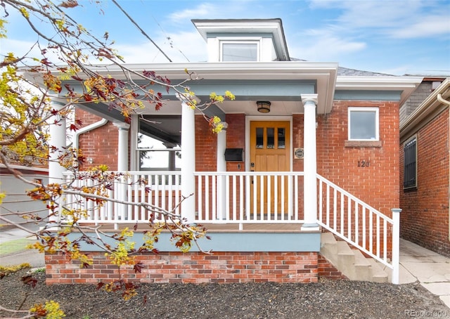view of front of home with a porch and brick siding