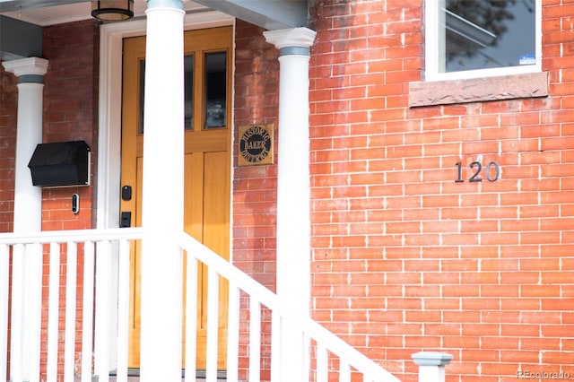 entrance to property featuring brick siding