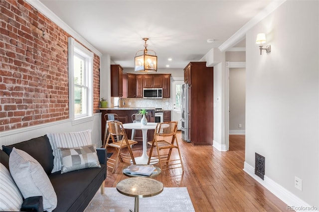 living room with a notable chandelier, plenty of natural light, and light wood-type flooring