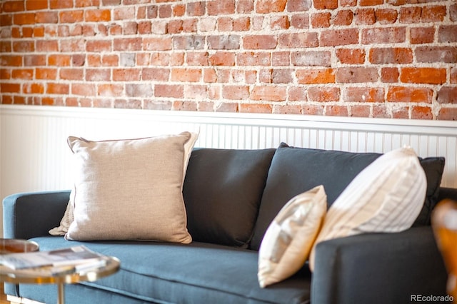 interior space with wainscoting and brick wall