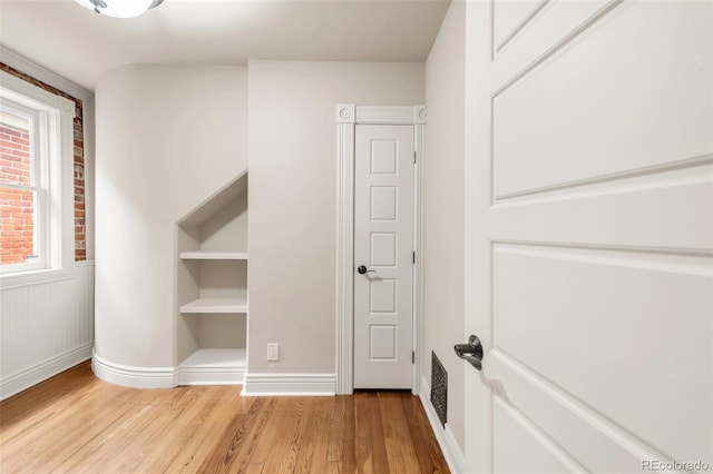 unfurnished bedroom featuring baseboards, wood finished floors, and visible vents