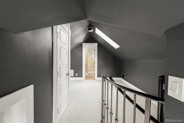 additional living space with carpet flooring, baseboards, and vaulted ceiling with skylight