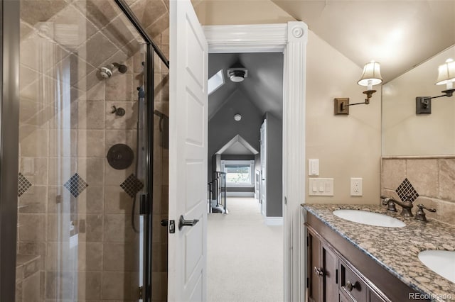 full bath with double vanity, a sink, a stall shower, and vaulted ceiling