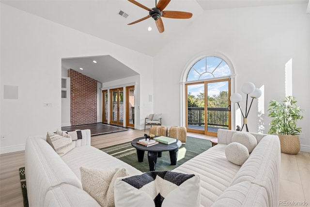 living area with recessed lighting, visible vents, a ceiling fan, wood finished floors, and high vaulted ceiling