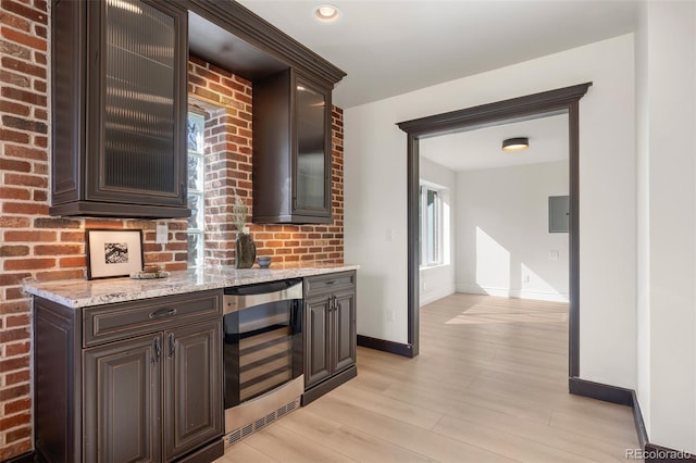 bar with recessed lighting, light wood-style flooring, beverage cooler, electric panel, and baseboards