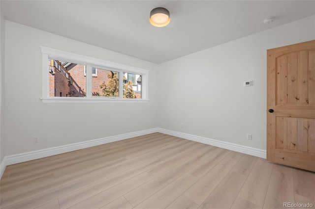 unfurnished room with light wood-style floors and baseboards