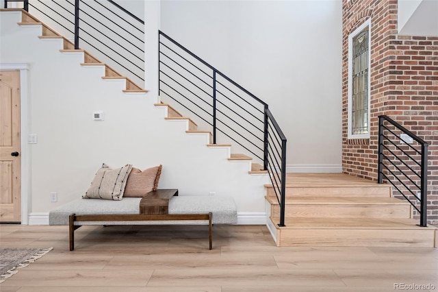 staircase with wood finished floors and baseboards