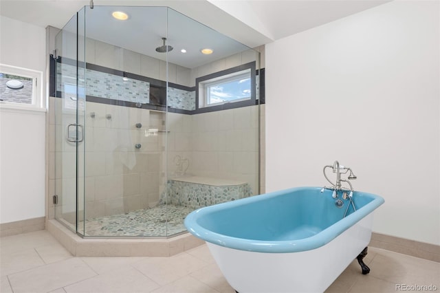 full bathroom with a freestanding tub, a shower stall, and tile patterned flooring