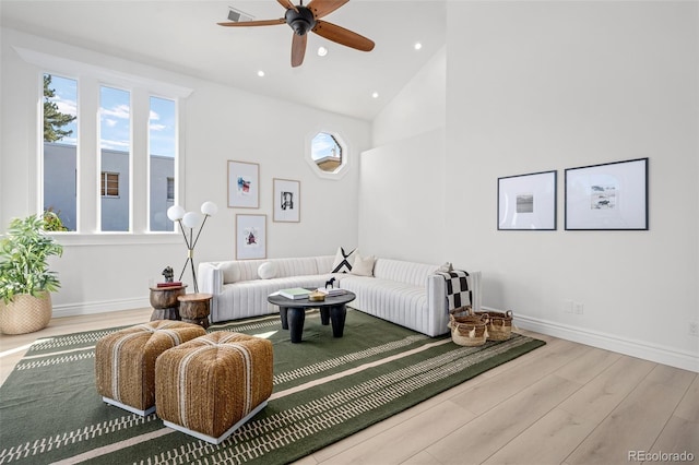 living area featuring high vaulted ceiling, recessed lighting, baseboards, and wood finished floors