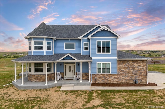 2490 Sagebrush St, Parker, CO 80138 - victorian house with roof with shingles, stone siding, covered porch, and a front lawn
