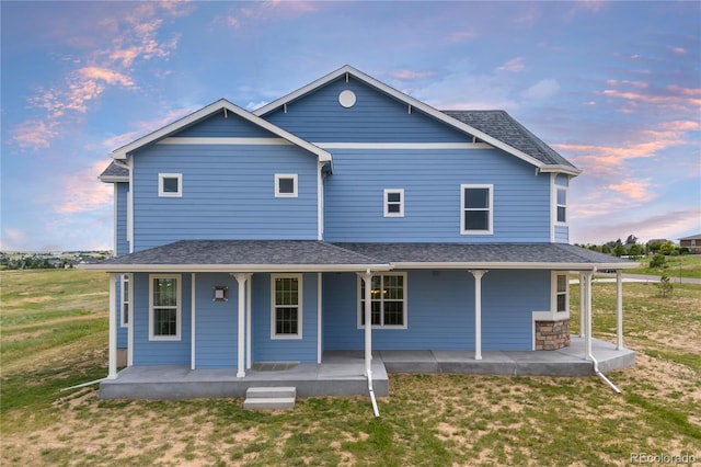 2490 Sagebrush St, Parker, CO 80138 - back of house at dusk with a lawn and covered porch