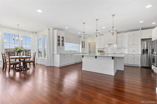 2490 Sagebrush St, Parker, CO 80138 - kitchen with appliances with stainless steel finishes, a chandelier, light countertops, decorative backsplash, and glass insert cabinets
