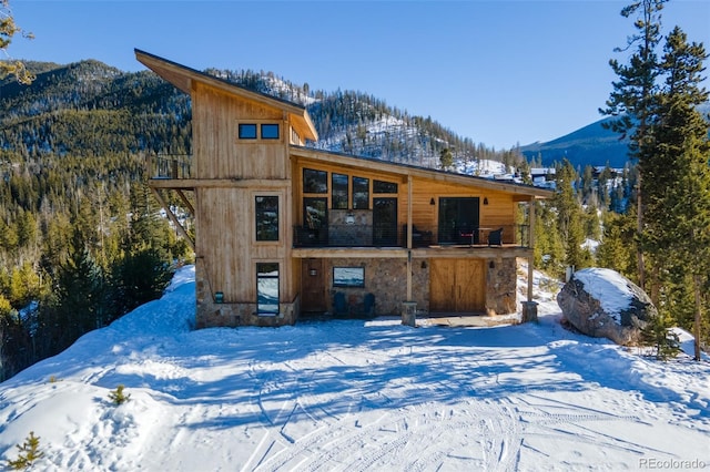 snow covered house featuring a mountain view