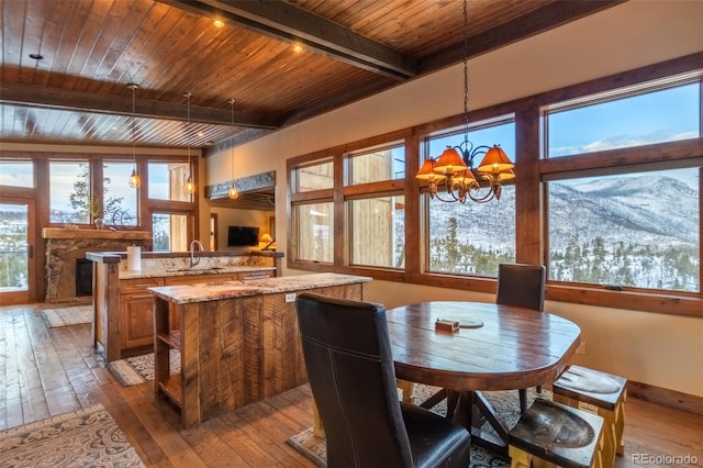 dining room with wooden ceiling, sink, light hardwood / wood-style flooring, beamed ceiling, and a chandelier