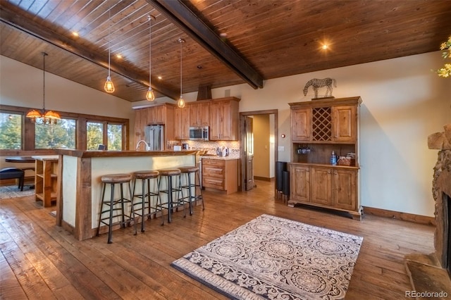 kitchen with stainless steel appliances, a chandelier, a spacious island, pendant lighting, and decorative backsplash