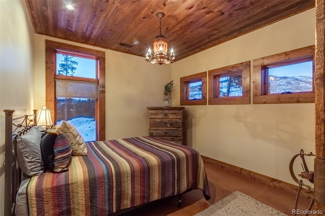 bedroom with a mountain view, a notable chandelier, and wood ceiling