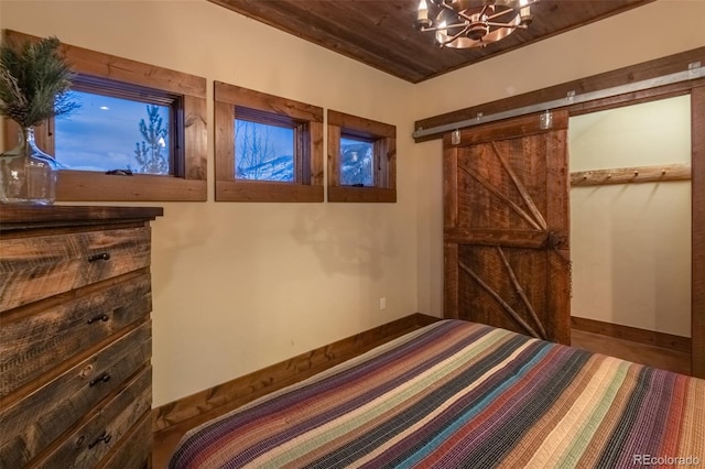 unfurnished bedroom featuring a barn door and wood ceiling