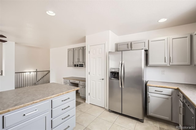 kitchen featuring black dishwasher, recessed lighting, gray cabinets, light tile patterned flooring, and stainless steel fridge