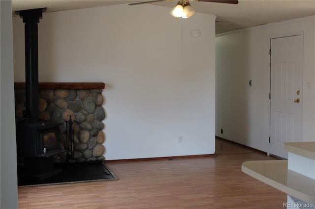 1692 US Highway 24, Leadville, CO 80461 - unfurnished living room featuring a wood stove, wood finished floors, a ceiling fan, and baseboards