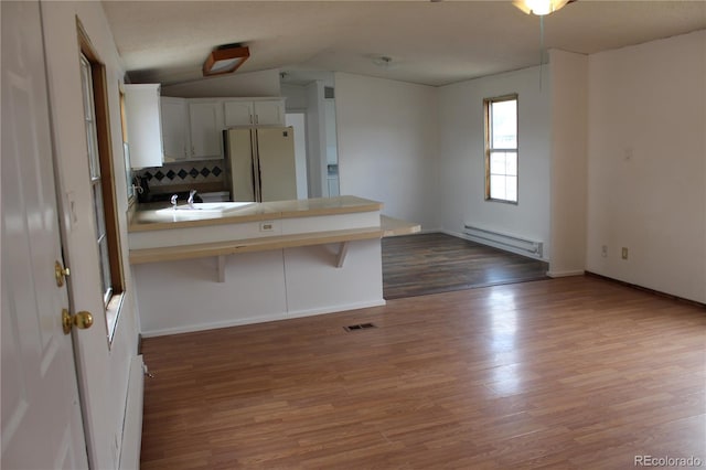 1692 US Highway 24, Leadville, CO 80461 - kitchen with freestanding refrigerator, a baseboard heating unit, backsplash, wood finished floors, and a peninsula