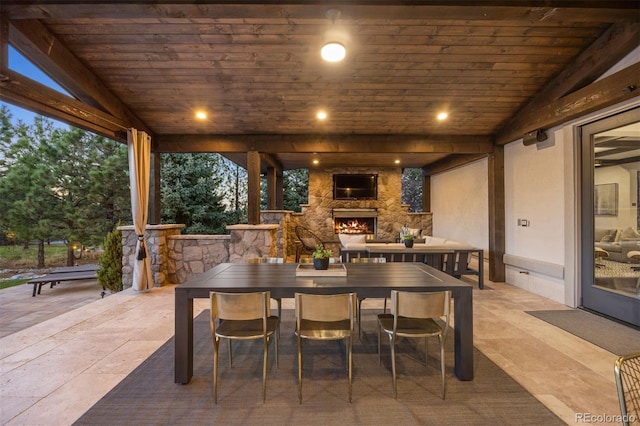 view of patio with an outdoor stone fireplace and outdoor dining area