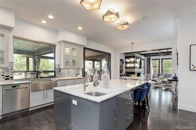 kitchen featuring dark wood-type flooring, stainless steel dishwasher, and a sink