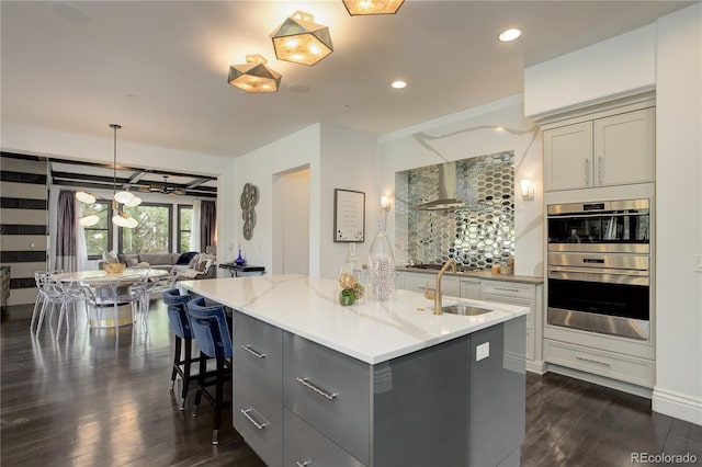 kitchen featuring a sink, gray cabinets, appliances with stainless steel finishes, and dark wood finished floors
