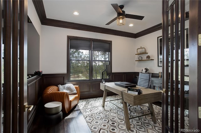 office area featuring light wood finished floors, a wainscoted wall, ceiling fan, and crown molding